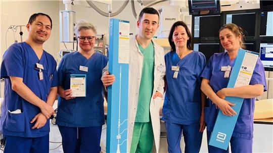 Dr. Halit Popi (M.), Oberarzt der Kardiologie der Asklepios-Harzkliniken, und sein Team mit einem noch verpackten kabellosen Herzschrittmacher.