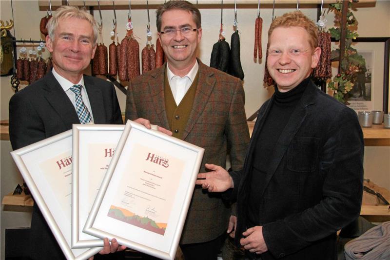 Dr. Thomas Lange (li.) und Andreas Lehmberg (re.) überreichen Harald Leiste die Urkunden für seine typischen Harzer Produkte.  Foto: Schlegel