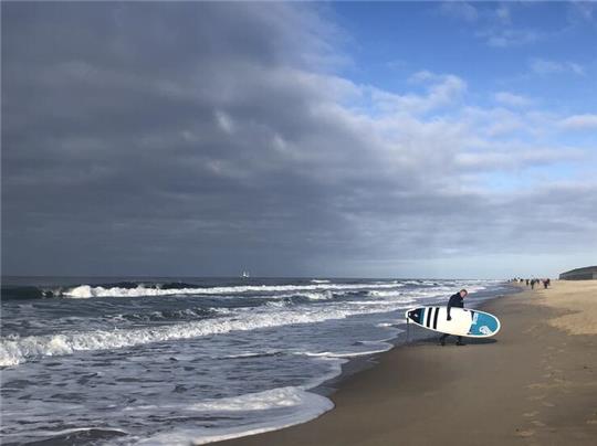 Dramatischer Himmel: Ein Surfer Anfang November am Strand von Westerland.