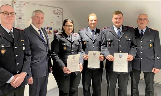 Drei Beförderungen können Ortsbrandmeister David Dankert (li.), Stadtbrandmeister Axel Breustedt (re.) und Bürgermeister Ralf Abrahms aussprechen: Denise Beckmann ist jetzt Hauptlöschmeisterin, Jonas Schrader Feuerwehrmann und Simon Lüder (2.v.re.) ist zum Oberfeuerwehrmann ernannt. Foto: Nachtweyh
