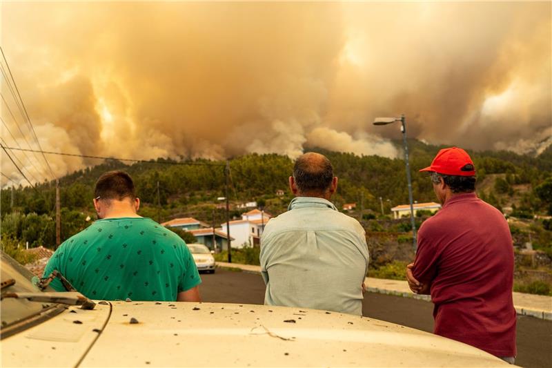 Waldbrand auf La Palma: Mehr als 4000 Menschen evakuiert Drei Männer beobachten den Waldbrand auf der Kanareninsel.