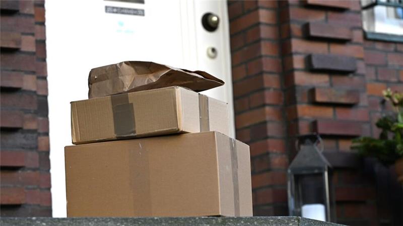 Ein Standort für alle Pakete? DHL-Tochter startet Automaten Drei Pakete liegen vor einer Haustür - für Paketfirmen ist dieser Lieferweg eine teure Sache. (Archivbild)