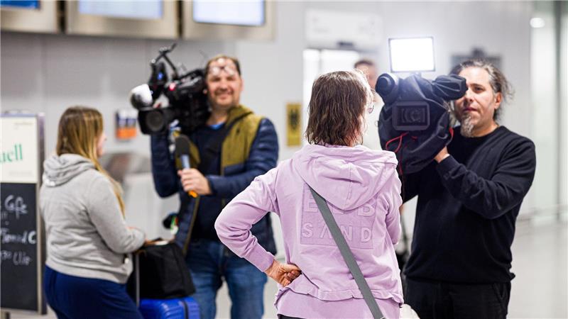 Dubai-Touristen geben nach ihrer Landung Kameramännern Interviews.