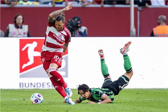 Düsseldorfs Daniel Ginczek (l.) und Hannovers Sei Muroya kämpfen um den Ball.