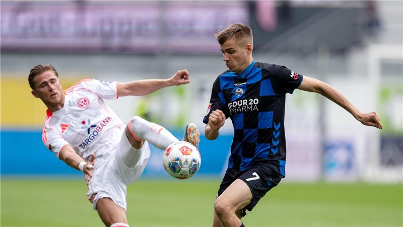 Düsseldorfs Tim Rossmann (l) und Paderborns Filip Bilbija kämpfen um den Ball.