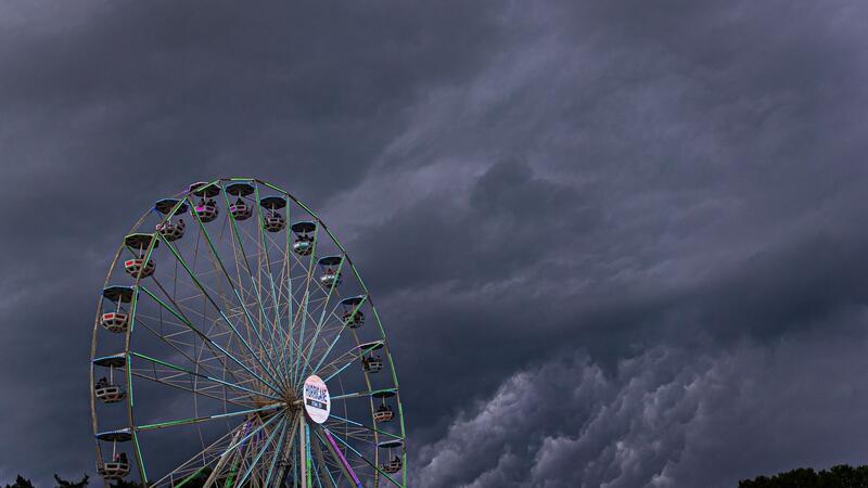 Dunkle Regenwolken ziehen über ein Riesenrad auf dem Gelände des Hurricane-Festivals in Scheeßel hinweg.