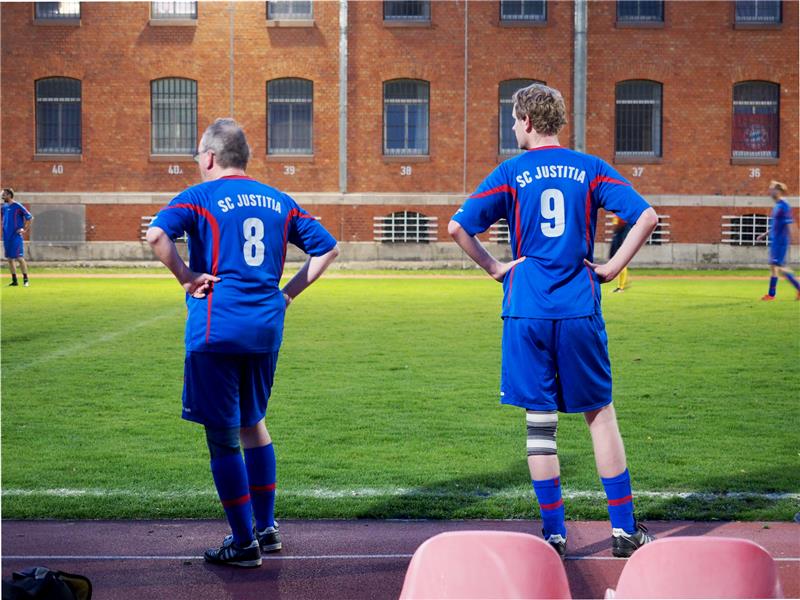 JVA Wolfenbüttel: Beim „Knast-Kick“ sind alle gleich Durchschnaufen und auf das nächste Match hoffen: Die Juristen des SC Justitia aus Braunschweig in den blau-roten Trikots unterlagen gegen eine Mannschaft aus Häftlingen der JVA Wolfenbüttel. Die Partien in der Vollzugsanstalt finden seit rund 20 Jahren statt. Foto: Erik Westermann