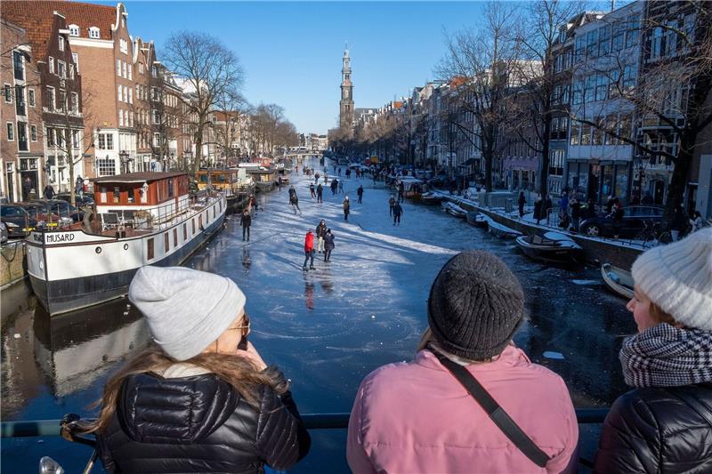 Frostwetter versetzt Niederlande ins Schlittschuhfieber Dutzende von Schlittschuhläufern laufen auf der gefrorenen Oberfläche von Amsterdams historischem Prinsengracht-Kanal.