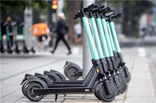 E-Tretroller stehen am Straßenrand.