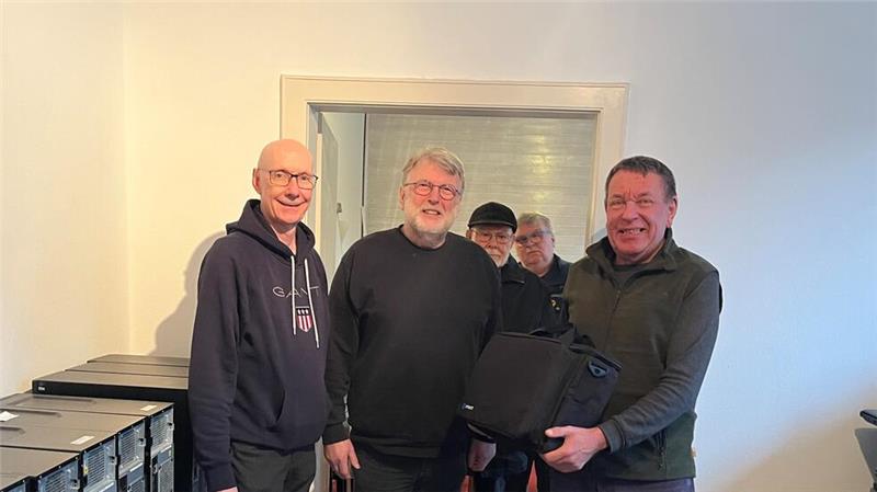 ERA-Vorstandsmitglied Malte Sandweg (r.) übergibt den Werkzeugkoffer an Wolfgang Dahncke. Links daneben ist Johannes Golisch. Im Hintergrund sind Peter Haufmann und Reinhard Greth.
