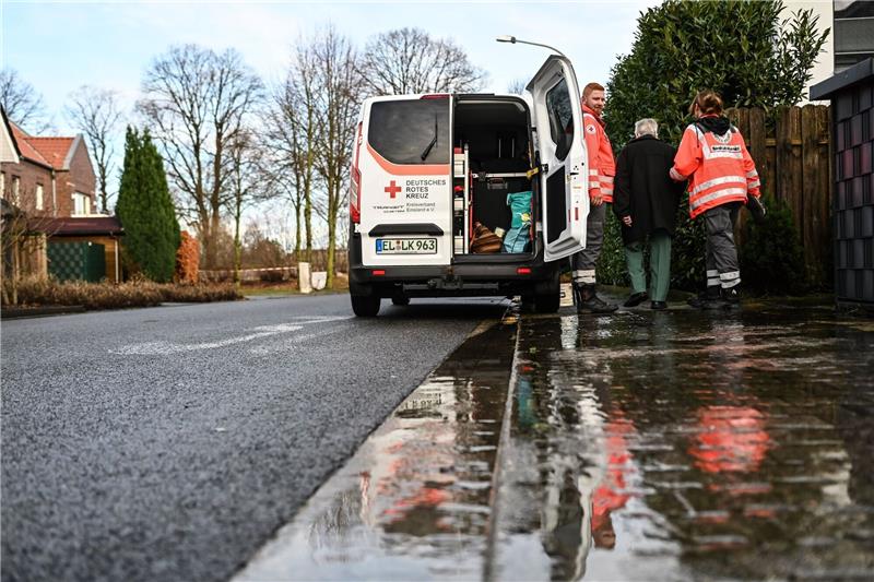 Ehrenamtliche Helfer vom DRK unterstützen bei der Evakuierung ältere Menschen im Flutgebiet.
