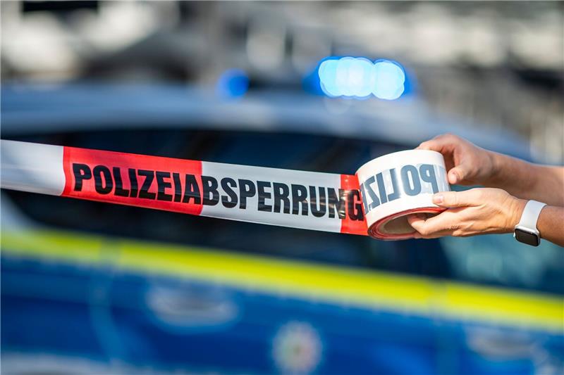 Wohnmobil für Prostitution brennt ab Ein Absperrband wird vor einem Polizeiwagen ausgerollt.