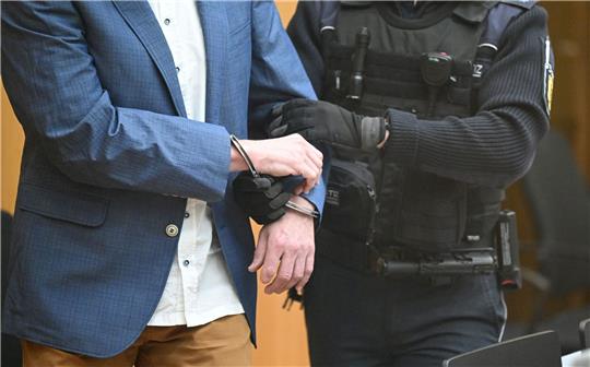 Ein Angeklagter bei Prozessbeginn in den Gerichtssaal geführt.