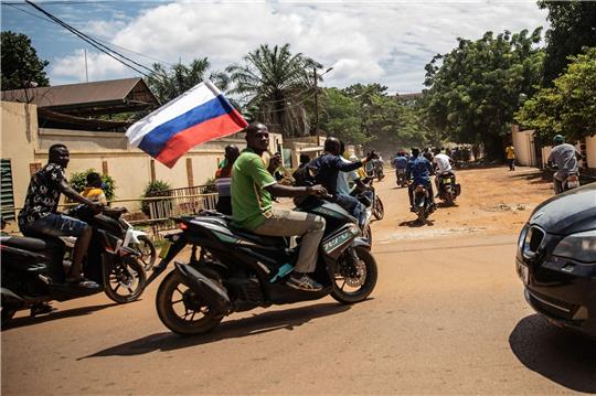 Ein Anhänger von Hauptmann Traore schwenkt eine russische Fahne auf einem Motorrad.