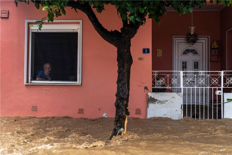 Griechische Stadt Volos nach Unwetter erneut unter Wasser Ein Anwohner blickt aus dem Fenster seines Hauses auf die überschwemmte Straße.