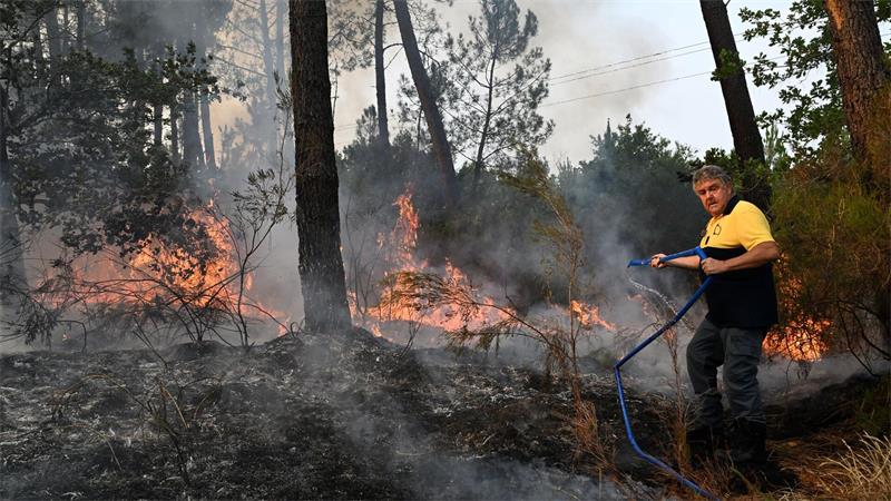 Unberechenbares Feuer kommt Metropolregion Bordeaux näher Ein Anwohner kämpft gegen die Flammen.