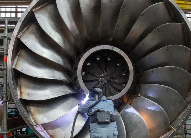 Ein Arbeiter eines Maschinen- und Anlagenbauers arbeitet an einer Wasserturbine.