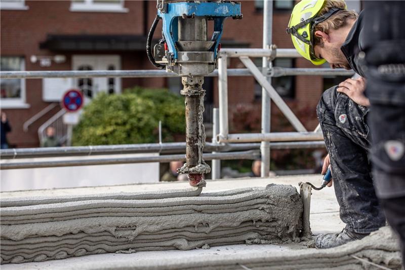 Haus aus dem 3D-Drucker: Neue Wege im Sozialen Wohnungsbau Ein Arbeiter inspiziert die Baustelle eines Mehrfamilienhauses aus dem 3D-Drucker.