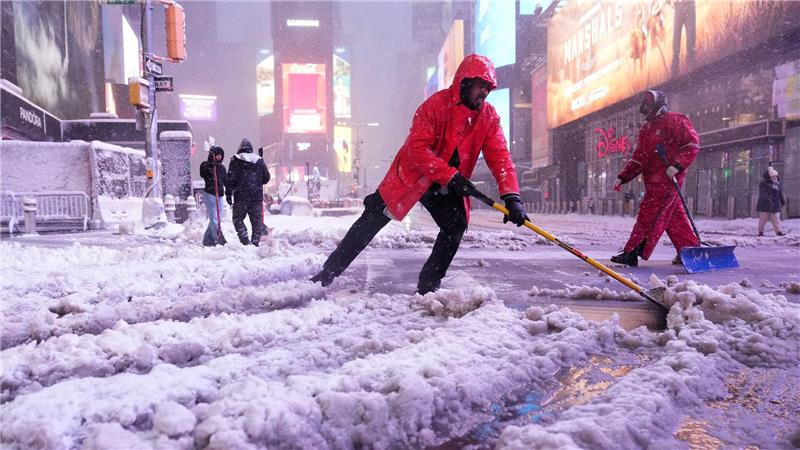 Ein Arbeiter schaufelt Schnee auf dem Times Square in New York. Ein heftiger Schneesturm zieht über den Nordosten der USA hinweg.