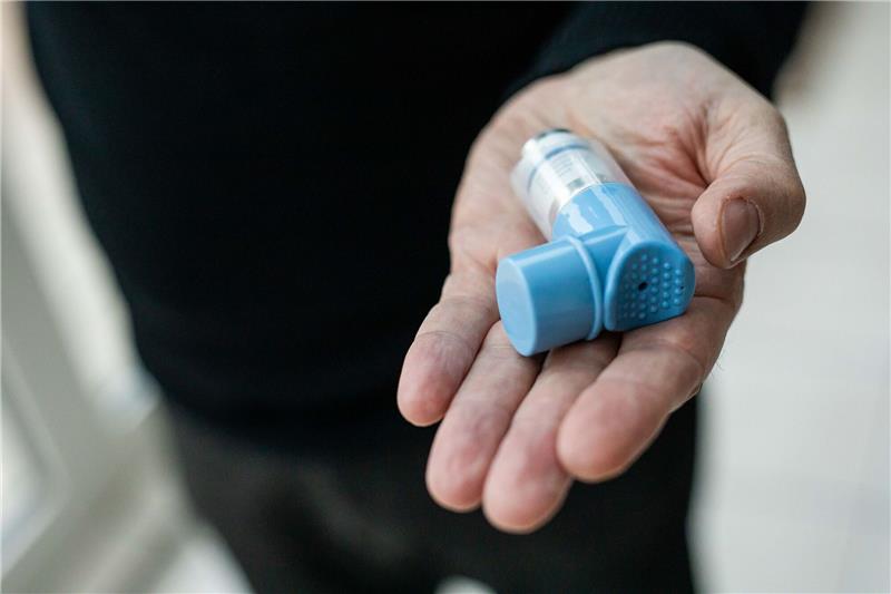 Ein Asthmatiker hält einen Asthmaspray in der Hand.