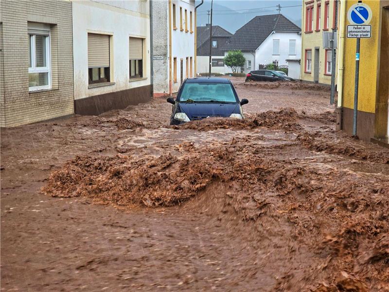 Ein Auto bahnt sich den Weg durch die Wassermassen.