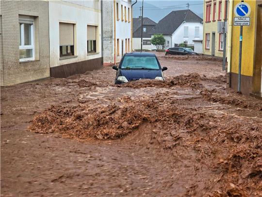 Ein Auto bahnt sich den Weg durch die Wassermassen.