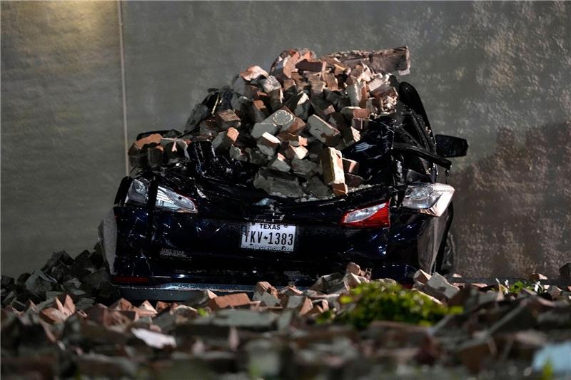 Mindestens vier Tote bei Unwettern in Texas Ein Auto, das von herabfallenden Ziegeln einer umgestürzten Hauswand zerquetscht wurde, steht auf einem Parkplatz in der Innenstadt von Houston.