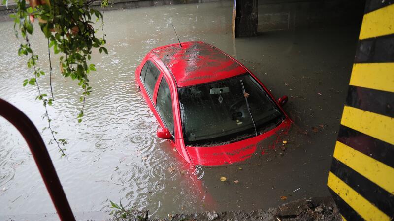Hochwasser in Tschechien: Tausende werden evakuiert Ein Auto steht unter einer Bahnlinie in einer überfluteten Unterführung im Wasser.