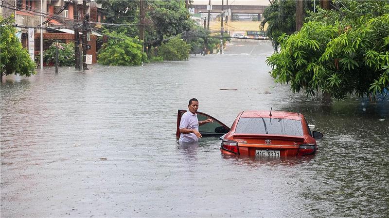 Ein Auto steht während eines starken Regens mit Überschwemmungen in Quezon City im tiefen Wasser.