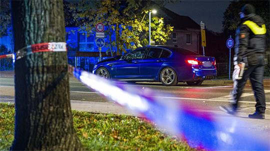 Ein BMW steht in der Nacht an einer Einsatzstelle in der Region Hannover. Einsatzkräfte haben zuvor auf ein Auto geschossen, dass zuvor in eine Gruppe von Menschen gefahren war.