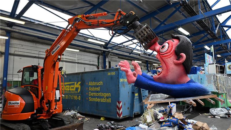Ein Bagger hebt in Düsseldorf eine Pappfigur eines Rosenmontagszugs in den Müll. Nachdem die Motive zahlreiche Zuschauer begeisterten, werden sie abgerissen.