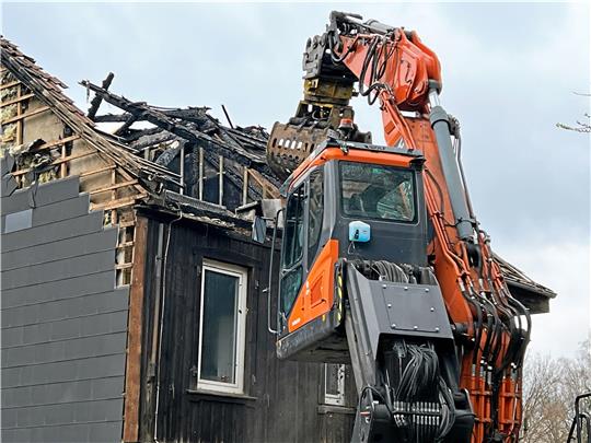 Ein Bagger trägt die Brandruine am Müllerkamp Schicht für Schicht ab. Foto: Polizei