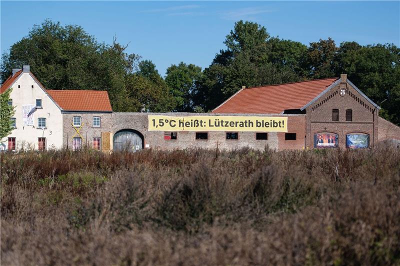 Schnellerer Kohleausstieg im Westen Ein Banner mit der Aufschrift «1,5 Grad heißt: Lützerath bleibt!» an einem alten Hof in Lützerath. Doch nun soll das Dorf weichen.