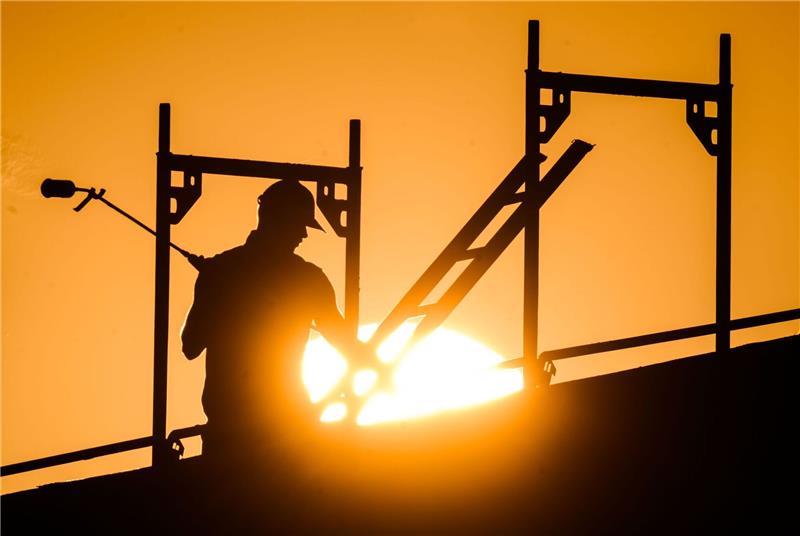 Mehr als 15.000 Ukrainer arbeiten in Niedersachsen Ein Bauarbeiter steht mit einem Gasbrenner beim Bau eines Mehrfamilienhauses im Neubaugebiet.