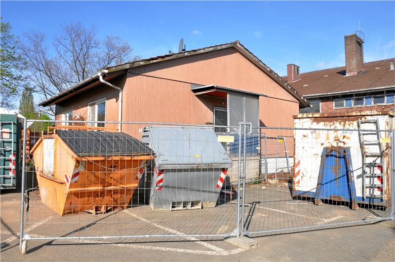 Oker: Sanierung der Mehrzweckhalle schreitet voran Ein Bauzaun, der Container einschließt: Seit Ostern läuft die Schadstoffsanierung in der Okeraner Mehrzweckhalle. Das alte Gemäuer gibt einiges her, was es auszuschlachten gilt. Da wird schon der eine oder andere große Behälter für den späteren Abtransport gebraucht. Die alte Hausmeisterwohnung nicht mehr – sie wird demnächst abgerissen, wie auch der Schwimmbeckenteil der Halle. Foto: Heine