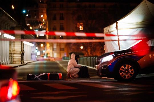 Ein Beamter der Kriminalpolizei arbeitet am Tatort unweit des Eiffelturms in Paris.