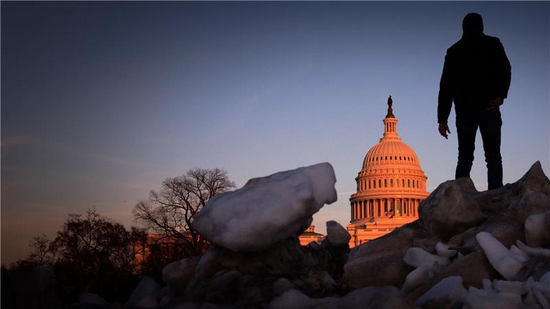Ein Besucher aus Tschechien klettert bei Sonnenuntergang auf einen Schneehaufen auf dem Capitol Hill in Washington.