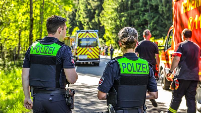Einsatzkräfte der Polizei stehen an einer Unfallstelle.