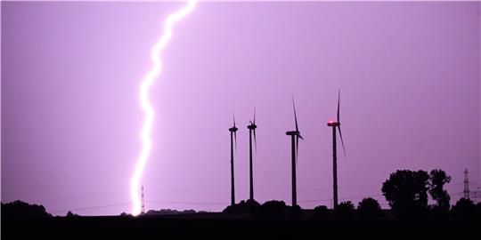 Ein Blitz entlädt sich bei Hildesheim vor Windmühlen am Horizont. Auch das Gebäudeenergiegesetz wird in der politischen Debatte noch von Blitz und Donner begleitet sein. Foto: dpa