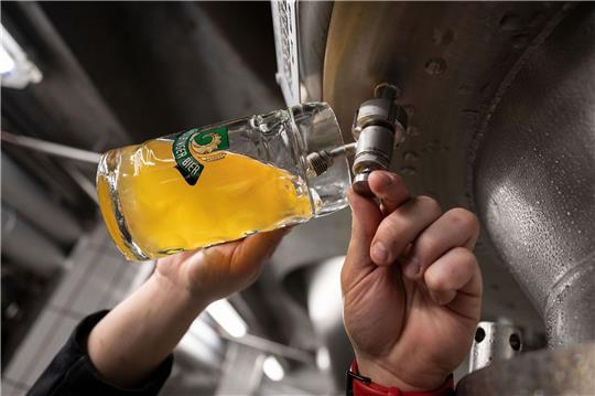 Ein Braumeister entnimmt Bier aus einem Tank. Weltweit wurde 2022 mehr Bier produziert als erwartet.