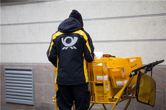 Ein Briefträger der Deutschen Post verteilt die Postsendungen an die Haushalte.