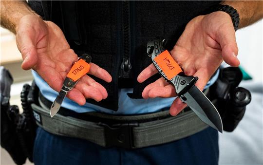 Ein Bundespolizist zeigt sichergestellte Messer.