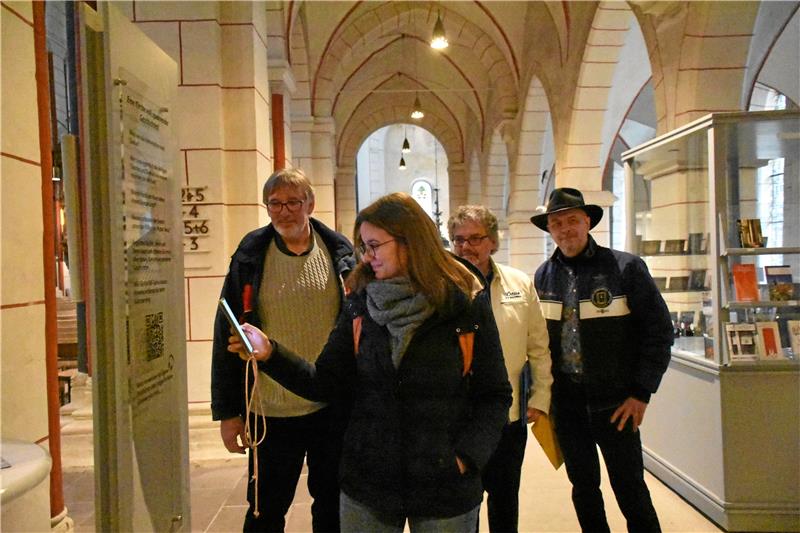 Ein „Churchwalk“ der anderen Art, nicht nur am Pfingstsamstag, sondern jeden Tag möglich. Von links: Propst Thomas Gunkel, Sabrina Seal, Andreas Blum und Martin Bolik probieren und präsentieren den neuen „Audiowalk“ in der Marktkirche. Hilfreich für das Abspielen vor Ort sind ein Handy mit QR-Code-Reader und eigene Kopfhörer. Foto: Kempfer
