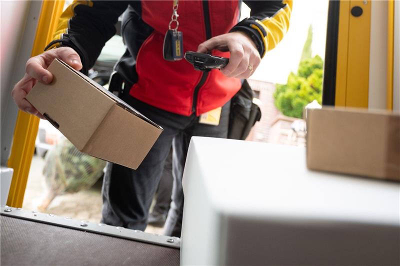 Auch Onlinehandel leidet unter Konsumflaute Ein DHL-Mitarbeiter scant ein Paket für die Zustellung.
