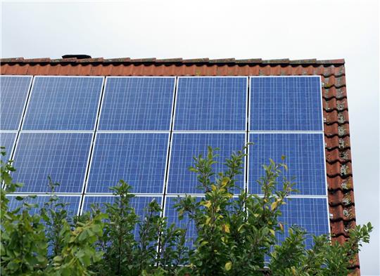 Ein Dach ist mit Photovoltaik-Modulen bestückt.