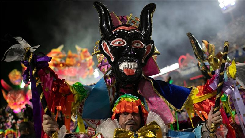 Ein Darsteller der Sambaschule Beija Flor zieht während der Karnevalsfeierlichkeiten im Sambadrom durch die Straßen.