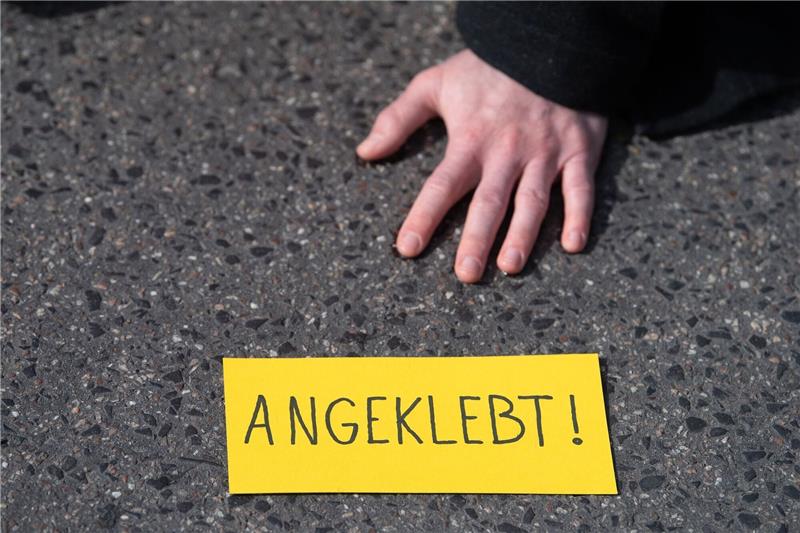 Ein Demonstrant hat sich während eines Protests der Gruppe «Letzte Generation» auf einer Straße festgeklebt.