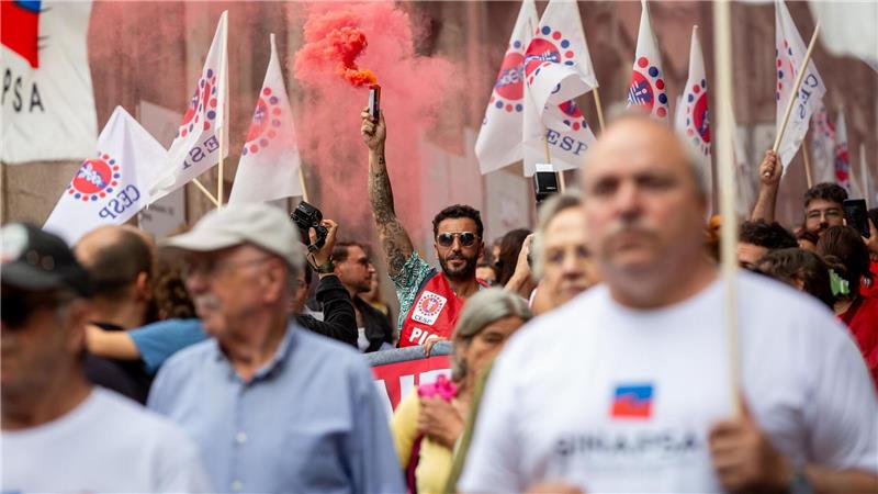 Ein Demonstrant hebt eine rote Fackel während eines eintägigen Generalstreiks und Protests in Porto gegen die geplante Arbeitsmarktreform der konservativen Regierung in Portugal.