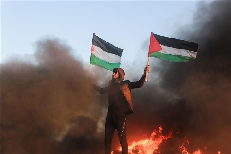 Nach Raketenangriff: Israel greift Ziele im Gazastreifen an Ein Demonstrant in Gaza mit palästinensischen Fahnen (Archivbild).
