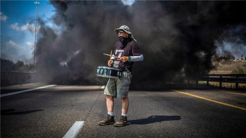 Ein Demonstrant trommelt bei einer Straßenblockade in Israel für die sofortige Freilassung aller von der Terrororganisation Hamas festgehaltenen Geiseln und das Ende des Krieges im Gazastreifen.